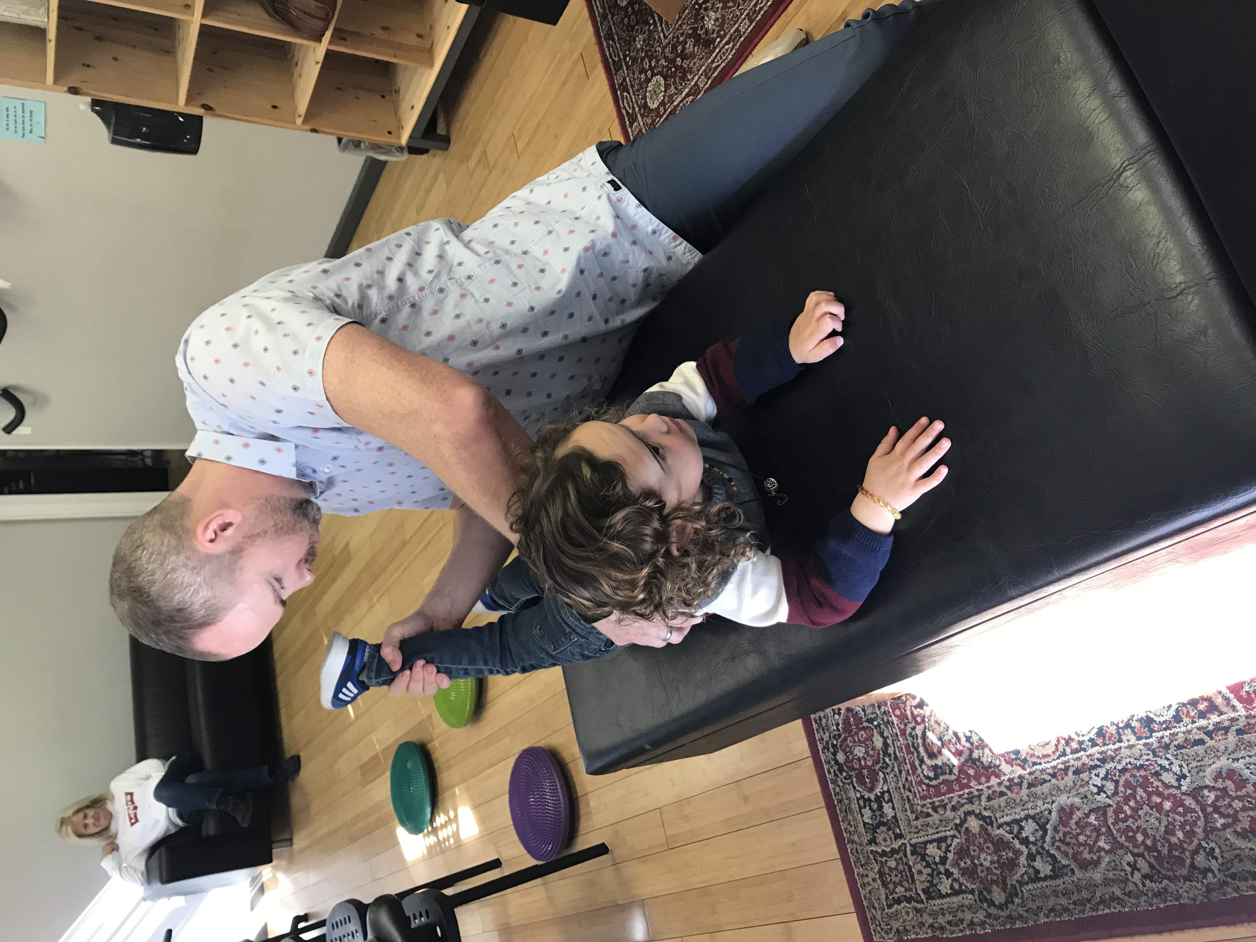 Dr. Tom adjusting a young child